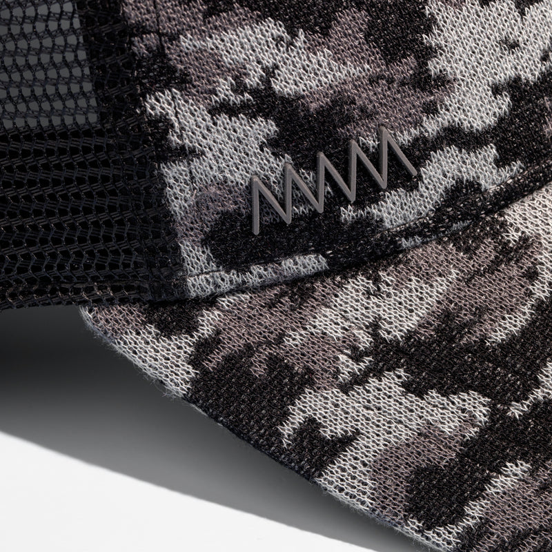 Close-up photo of a camo-patterned cap to show the logo