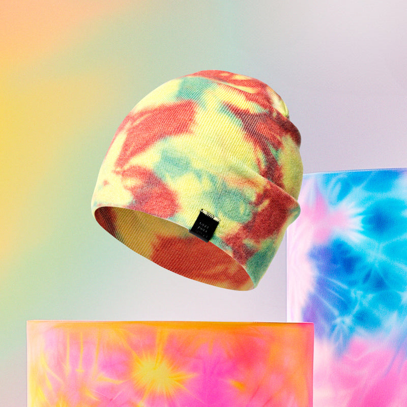 Beanie floating near tie-dye-colored abstract objects
