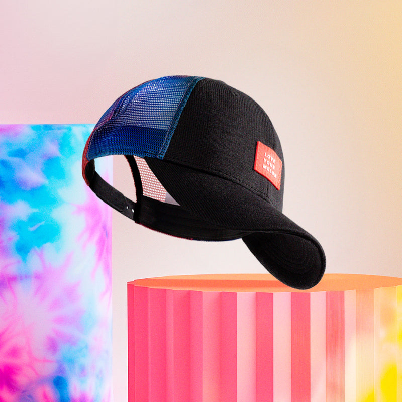 Mesh cap floating near tie-dye-colored abstract objects